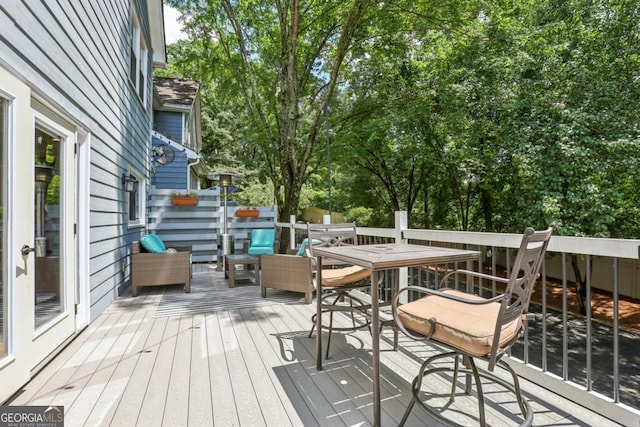 deck featuring outdoor dining area and view of scattered trees