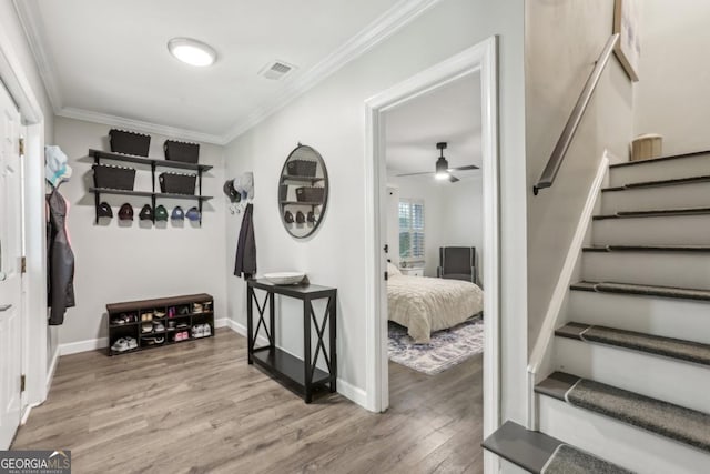 mudroom featuring crown molding, wood finished floors, a ceiling fan, and baseboards