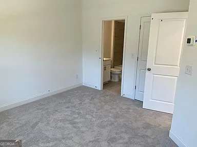 1616 Avery Way, Tucker, GA 30084 - unfurnished bedroom featuring carpet flooring, baseboards, and connected bathroom