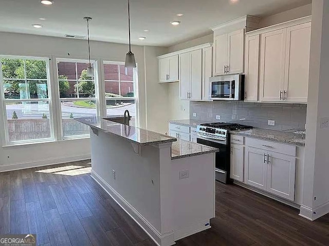 1616 Avery Way, Tucker, GA 30084 - kitchen featuring stainless steel appliances, dark wood finished floors, an island with sink, white cabinetry, and tasteful backsplash