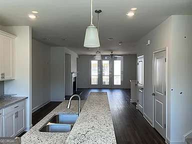 1616 Avery Way, Tucker, GA 30084 - kitchen with open floor plan, a sink, baseboards, dark wood-style flooring, and white cabinetry