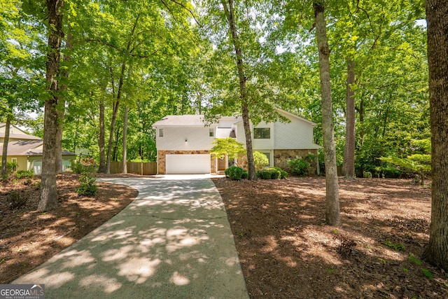 view of front of home with driveway, an attached garage, fence, and brick siding