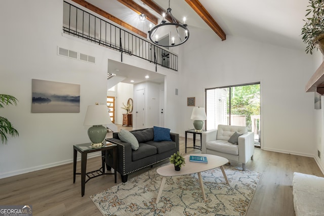 living area with high vaulted ceiling, beam ceiling, a chandelier, wood finished floors, and baseboards