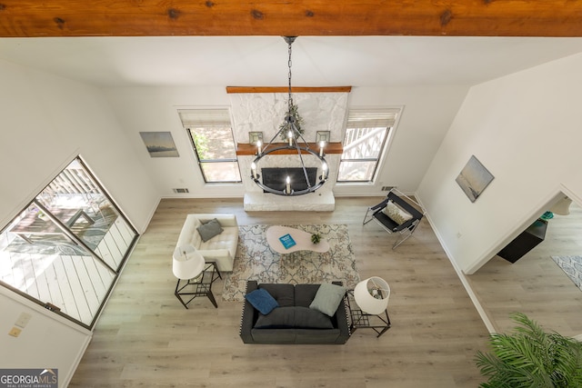 living room featuring a chandelier, wood finished floors, and beamed ceiling