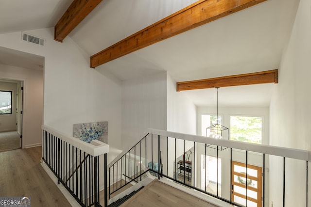 corridor with an upstairs landing, a chandelier, wood finished floors, and baseboards