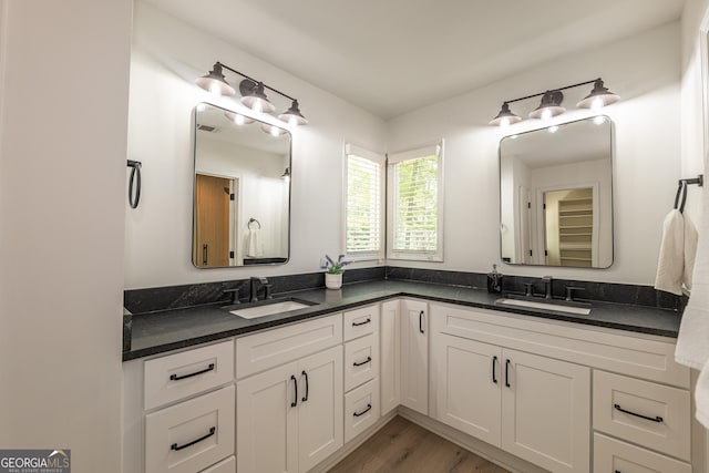 bathroom featuring double vanity and wood finished floors