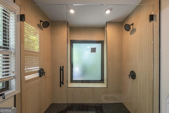 bathroom with a tile shower, plenty of natural light, and tile patterned flooring
