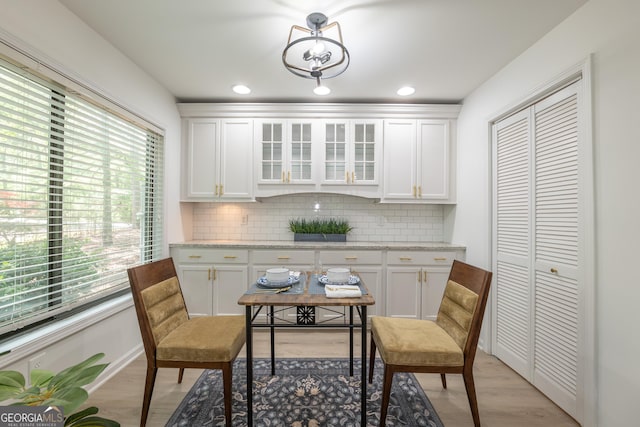 kitchen featuring plenty of natural light, decorative backsplash, glass insert cabinets, and recessed lighting