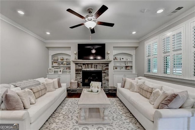 living area featuring crown molding, ceiling fan, built in shelves, wood finished floors, and a fireplace