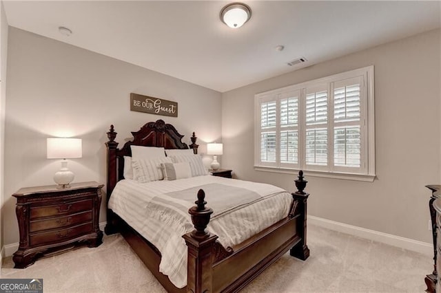bedroom with light colored carpet and baseboards