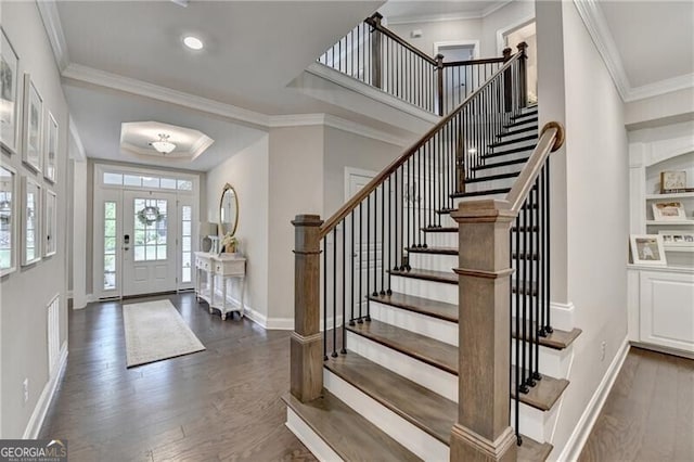 foyer featuring wood finished floors, stairs, baseboards, ornamental molding, and recessed lighting