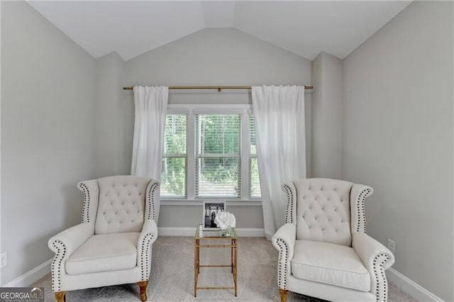 living area with baseboards, lofted ceiling, and carpet floors