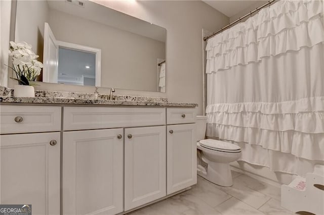 bathroom featuring marble finish floors, toilet, vanity, and shower / bath combo
