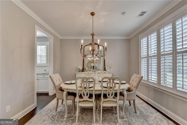 dining space featuring healthy amount of natural light, a chandelier, dark wood-style flooring, baseboards, and crown molding
