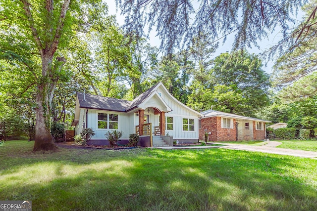 3275 Dodson Dr, East Point, GA 30344 - ranch-style home featuring board and batten siding, a front yard, and brick siding