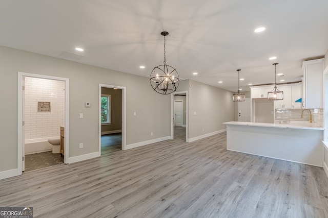 3275 Dodson Dr, East Point, GA 30344 - unfurnished living room with recessed lighting, light wood-style floors, a chandelier, a sink, and baseboards