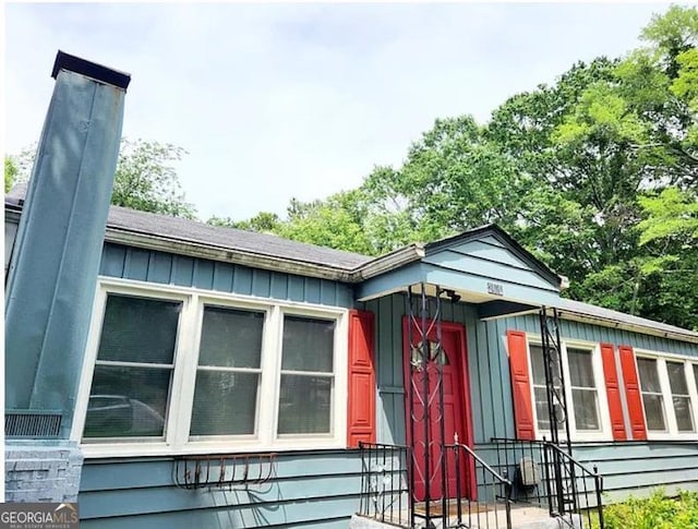 view of side of property with board and batten siding and a chimney