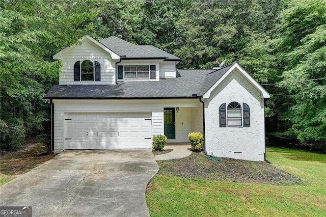 view of front facade featuring driveway, a garage, roof with shingles, and a front yard