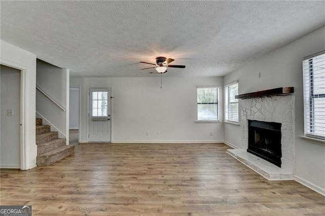 4278 Trotters Ln, Auburn, GA 30011 - unfurnished living room with a ceiling fan, a textured ceiling, wood finished floors, and plenty of natural light