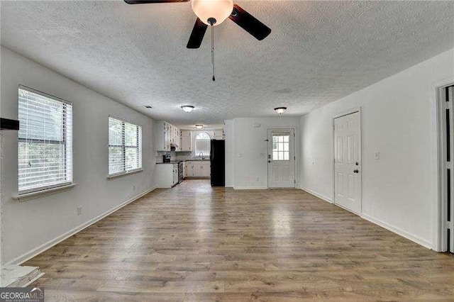 4278 Trotters Ln, Auburn, GA 30011 - unfurnished living room featuring a textured ceiling, wood finished floors, and a ceiling fan