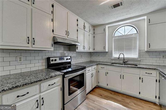 kitchen with stainless steel electric stove, a sink, under cabinet range hood, light wood-style flooring, and white cabinets