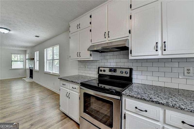 kitchen featuring electric stove, under cabinet range hood, white cabinets, baseboards, and light wood-style floors