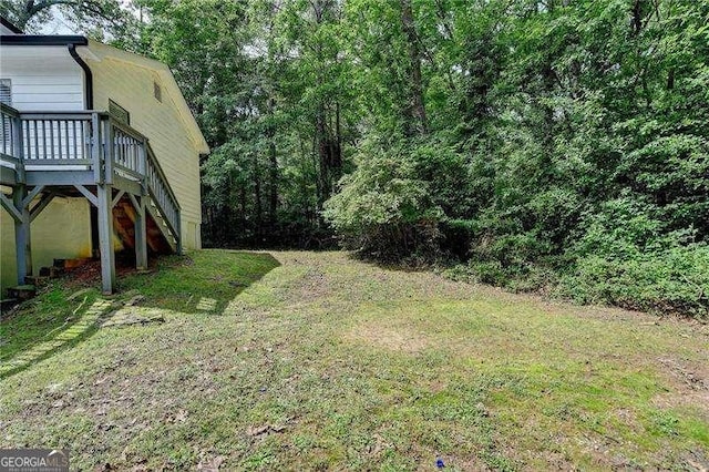 view of green lawn featuring a deck