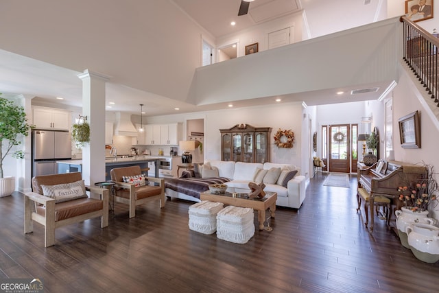 295 Graceton Farms Dr, Senoia, GA 30276 - living room featuring a towering ceiling, dark wood-type flooring, ornate columns, and recessed lighting