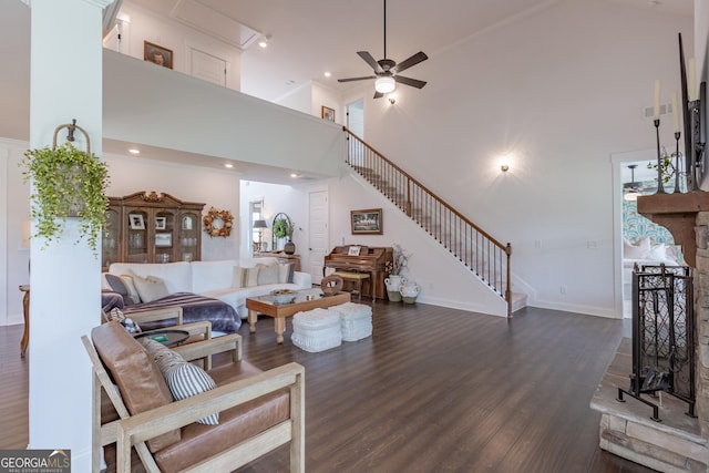 295 Graceton Farms Dr, Senoia, GA 30276 - living area featuring a high ceiling, stairs, dark wood-style flooring, ceiling fan, and baseboards