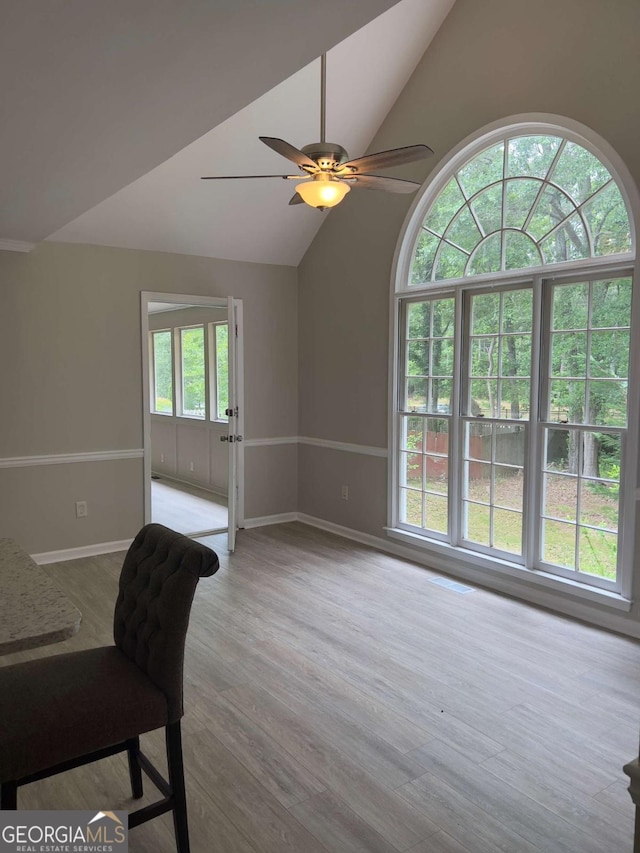 unfurnished office featuring vaulted ceiling, ceiling fan, baseboards, and wood finished floors