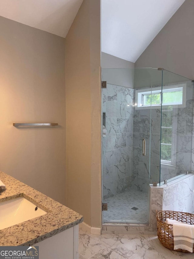 full bath featuring marble look tiles, a marble finish shower, vanity, and lofted ceiling
