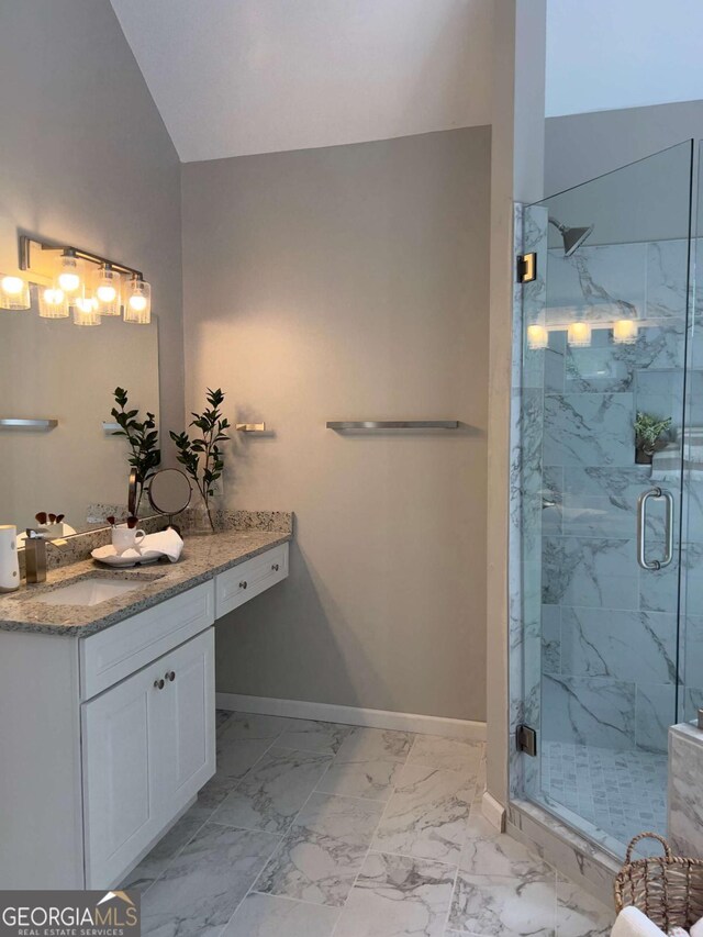 bathroom with marble look tile flooring, baseboards, and a marble finish shower