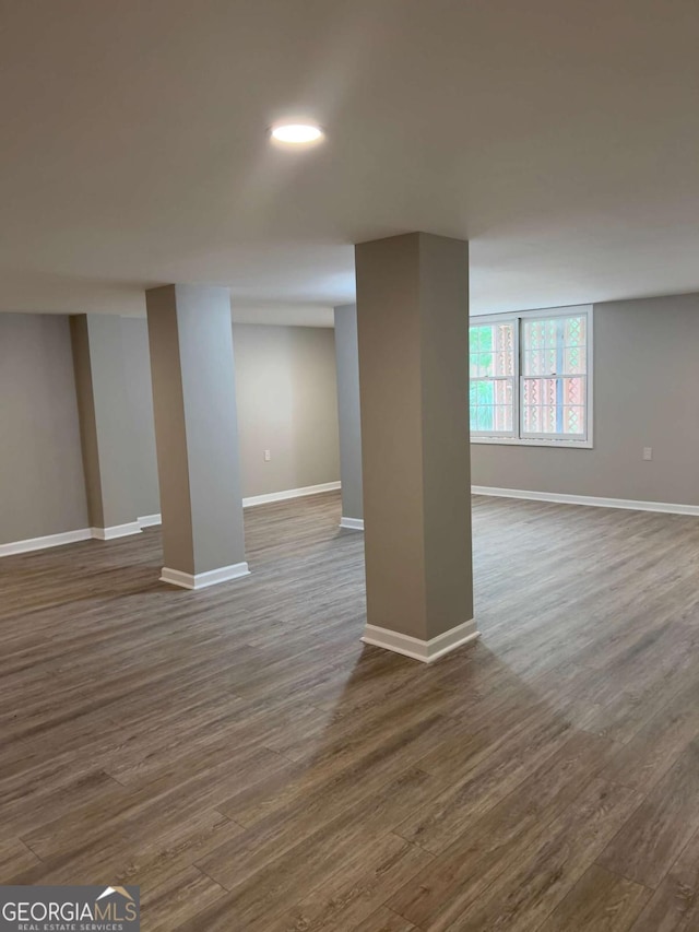 below grade area featuring dark wood-style flooring and baseboards