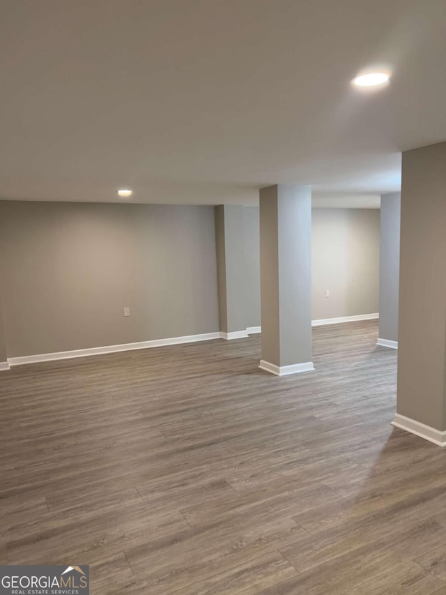 finished below grade area featuring recessed lighting, wood finished floors, and baseboards