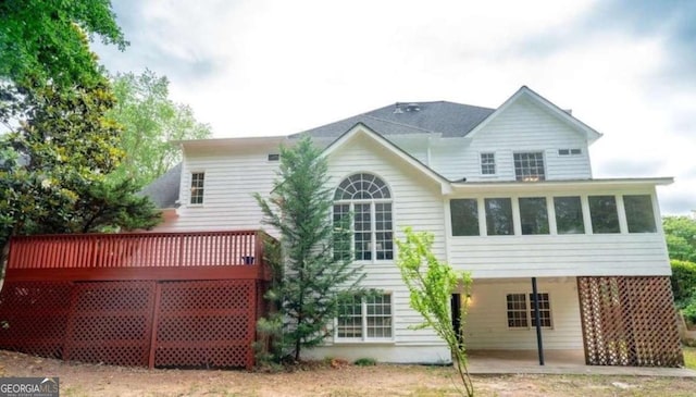 rear view of house featuring a wooden deck and a patio