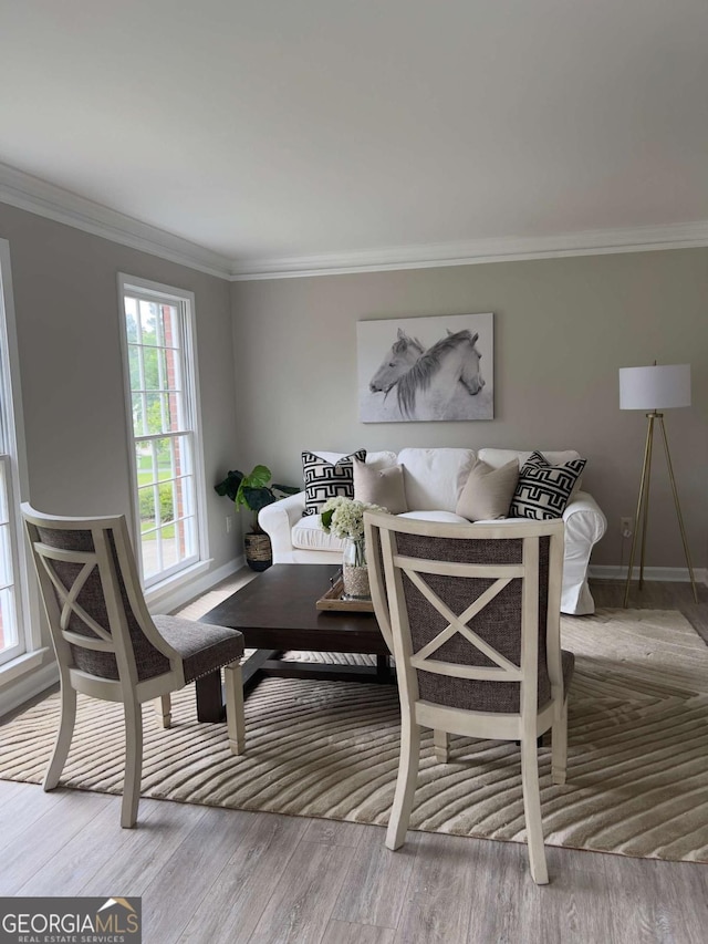 dining area with ornamental molding, baseboards, and wood finished floors