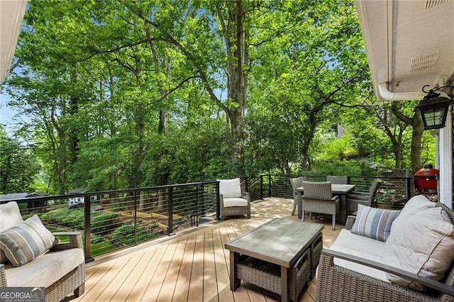 deck featuring an outdoor living space and view of scattered trees