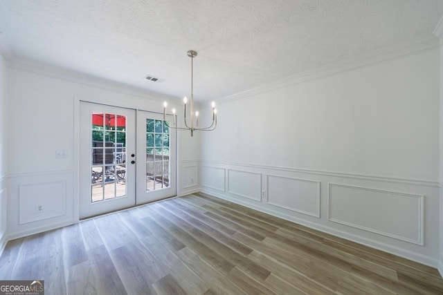 3350 Serenade Ct, Alpharetta, GA 30004 - unfurnished dining area featuring a chandelier, french doors, a decorative wall, crown molding, and wood finished floors