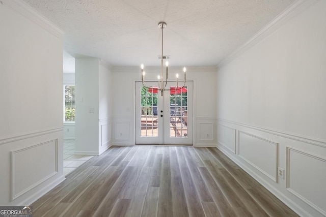 3350 Serenade Ct, Alpharetta, GA 30004 - unfurnished dining area featuring a decorative wall, healthy amount of natural light, a chandelier, crown molding, and wood finished floors