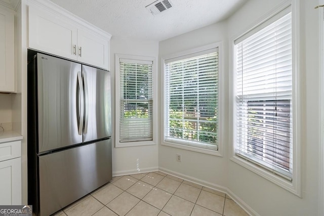 3350 Serenade Ct, Alpharetta, GA 30004 - kitchen with freestanding refrigerator, white cabinets, baseboards, light countertops, and light tile patterned floors