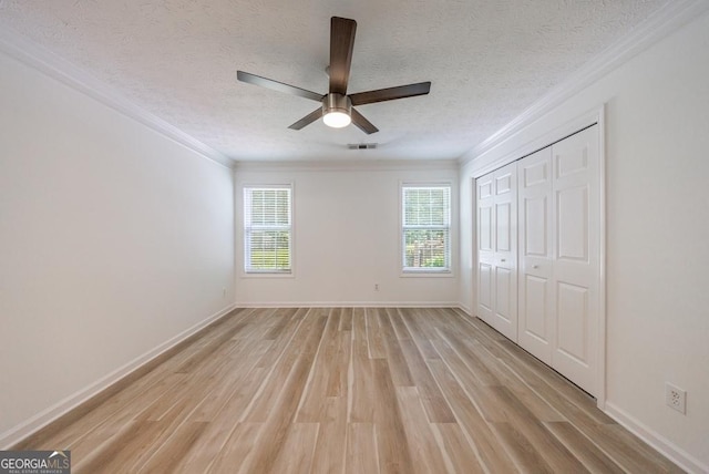 3350 Serenade Ct, Alpharetta, GA 30004 - unfurnished bedroom featuring light wood-style flooring, a textured ceiling, crown molding, baseboards, and a closet