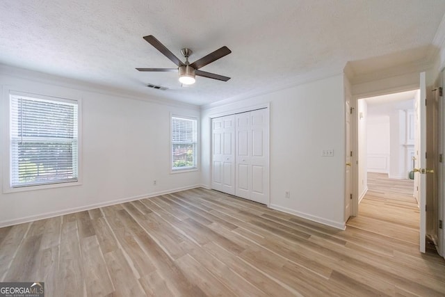 3350 Serenade Ct, Alpharetta, GA 30004 - unfurnished bedroom featuring multiple windows, light wood-style floors, baseboards, a textured ceiling, and crown molding