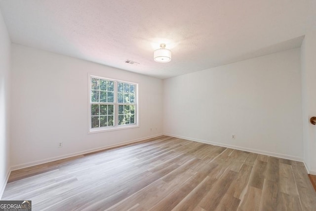 3350 Serenade Ct, Alpharetta, GA 30004 - empty room featuring light wood-style flooring, baseboards, and a textured ceiling