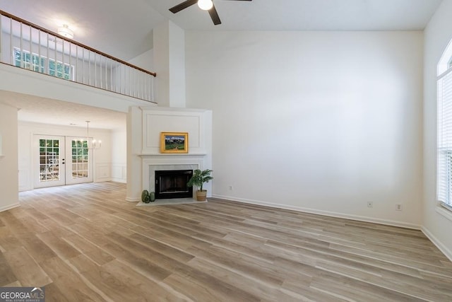3350 Serenade Ct, Alpharetta, GA 30004 - unfurnished living room featuring light wood-type flooring, a ceiling fan, high vaulted ceiling, healthy amount of natural light, and french doors