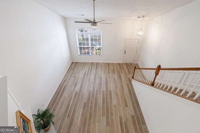 3350 Serenade Ct, Alpharetta, GA 30004 - unfurnished living room featuring light wood finished floors, ceiling fan, and baseboards