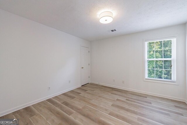 3350 Serenade Ct, Alpharetta, GA 30004 - unfurnished room featuring light wood-style floors, baseboards, and a textured ceiling