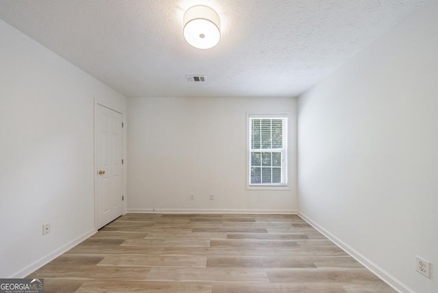 3350 Serenade Ct, Alpharetta, GA 30004 - empty room with light wood finished floors, a textured ceiling, and baseboards