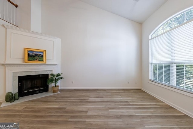 3350 Serenade Ct, Alpharetta, GA 30004 - unfurnished living room featuring vaulted ceiling, light wood-type flooring, a fireplace, and baseboards
