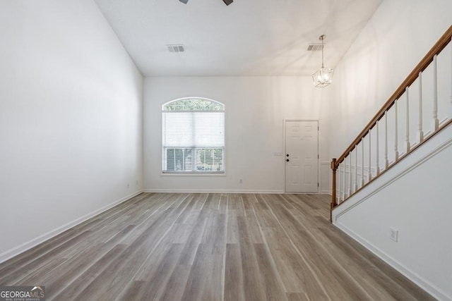 3350 Serenade Ct, Alpharetta, GA 30004 - unfurnished living room with stairway, light wood-type flooring, a ceiling fan, a chandelier, and baseboards
