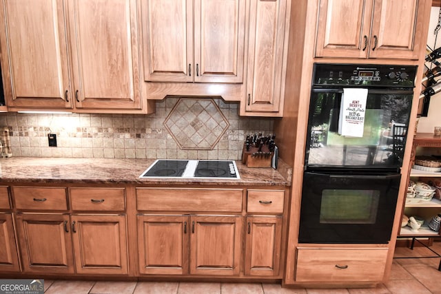 kitchen with black appliances, light stone counters, light tile patterned flooring, and tasteful backsplash
